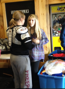 Erin helps a girl get a proper fitting set of shoulder pads :)